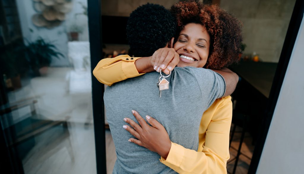 Ecstatic couple holding keys to new home