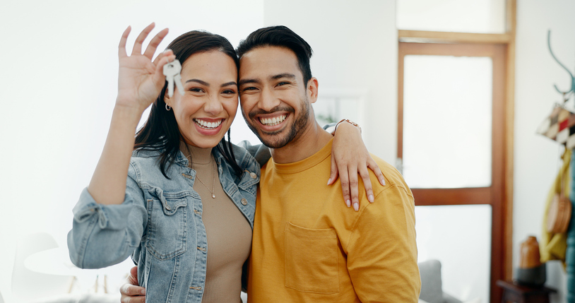 New home keys, hug and portrait of happy couple moving into house, real estate property or apartment purchase. Love, homeowner smile and Mexican man, woman or relocation people embrace in living room